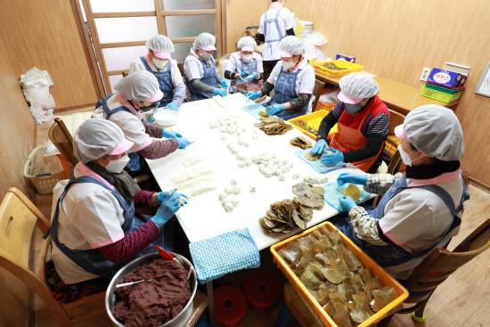 아주머니들이 위생복을 차려입고 의령망개떡을 손수 만들고 있다