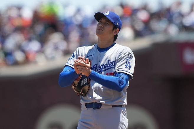 오타니 쇼헤이가 2회말 2사후 이정후를 스트레이트 볼넷으로 내보낸 뒤 공을 닦으며 하늘을 쳐다보고 있다. Imagn Images연합뉴스