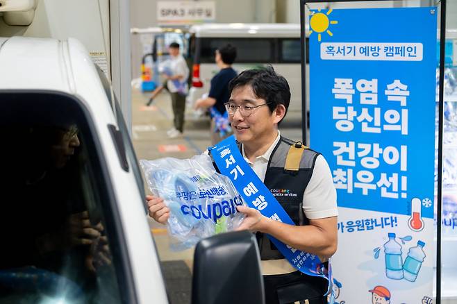홍용준 CLS대표이사와 위탁배송업체 대표 등이 13일 오후 서울 송파 캠프에서 퀵플렉서들에게 온열질환 예방 물품을 지급하고 있다./쿠팡로지스틱스서비스 제공