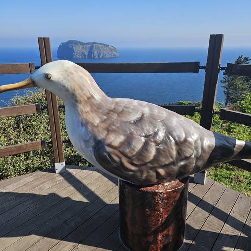 관음도의 깍새 조형물. 저 멀리 죽도가 보인다.