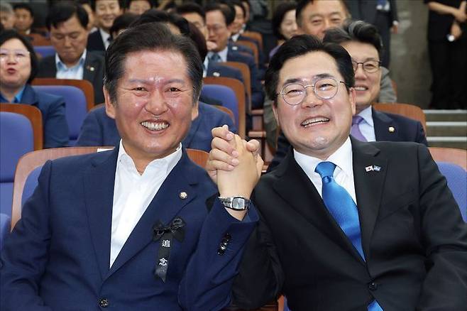 더불어민주당 당대표 출마를 선언한 정청래· 박찬대 의원이 지난달 24일 국회에서 열린 민주당 의원총회에서 함께 손을 맞잡으며 환하게 웃고 있다. ⓒ데일리안 홍금표 기자