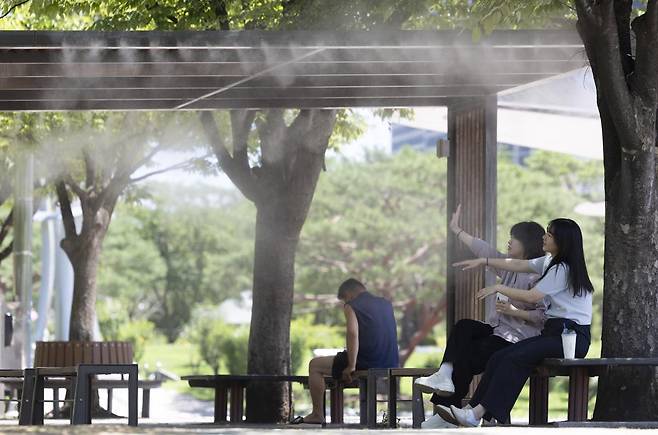 연일 폭염이 계속되는 가운데 11일 서울 영등포구 여의도 공원에서 시민들이 쿨링포그를 맞으며 더위를 피하고 있다. 2025.07.11. [서울=뉴시스]