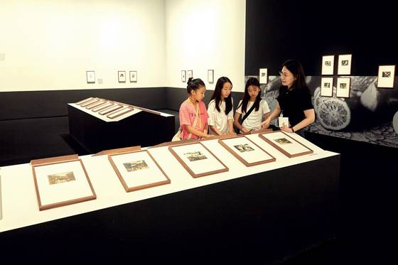 손현정(맨 오른쪽) 학예연구사가 소중 학생기자단에게 '광채: 시작의 순간들' 전시에 소개된 여러 작가에 관해 설명했다.