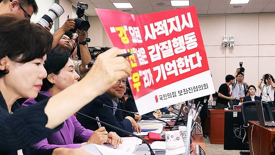 14일 국회 여성가족위원회에서 열린 강선우 여성가족부 장관 후보자 인사청문회에서 국민의힘 간사인 조은희 의원이 사퇴를 요구하는 피켓을 붙이고 있다. 연합뉴스