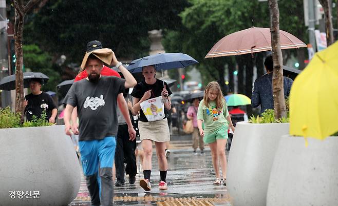 양산·우산은 필수…‘변화무쌍’ 여름 날씨  전국 곳곳에 더위를 식히는 비가 내린 14일 서울 광화문광장 인근에서 외국인 관광객들이 빗속을 걸어가고 있다. 기상청은 대부분의 지역에서 비는 그치겠지만 강원 영동 일부 지역에는 15일 오후까지 비가 내린다고 예보했다. 정지윤 선임기자 color@kyunghyang.com