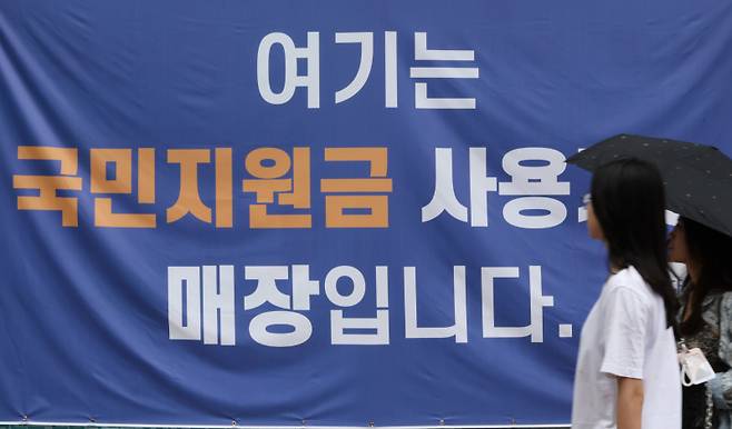 지난 13일 서울 한 상점에 붙은 민생회복 소비쿠폰 사용처 안내문 모습. 연합뉴스