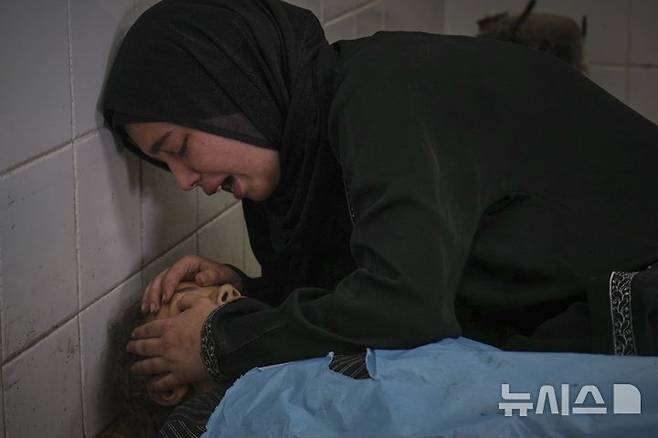 [가자지구=AP/뉴시스] 가자지구 데이르 알발라에 있는 '프로젝트 호프' 운영 의료 클리닉 앞에서 영양 보충제를 기다리다 이스라엘의 공습으로 숨진 13세 여동생 사마의 시신을 붙잡고 오열하고 있다.