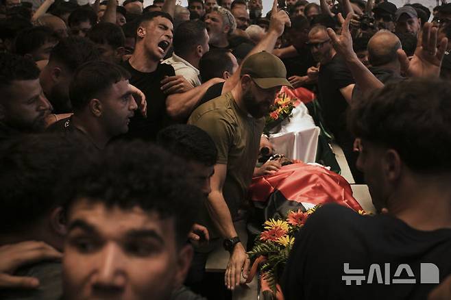 [알마즈라=AP/뉴시스] 13일(현지 시간) 가자지구 알마즈라 아샤르키야 마을에서 열린 팔레스타인계 미국인의 장례식에서 조문객들이 시신을 옮기고 있다. 팔레스타인 보건부에 따르면, 무살레트는 이스라엘의 공격으로 사망했다. 2025.07.14.