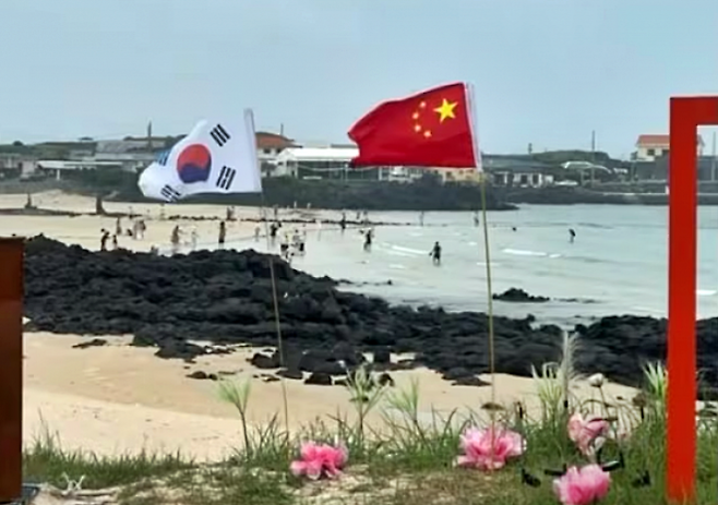 10일 소셜미디어(SNS) 스레드 이용자에 따르면 지난 8일 우도 해안도로변에서 나란히 꽂힌 오성홍기와 태극기가 포착됐다. 2025.7.10 스레드