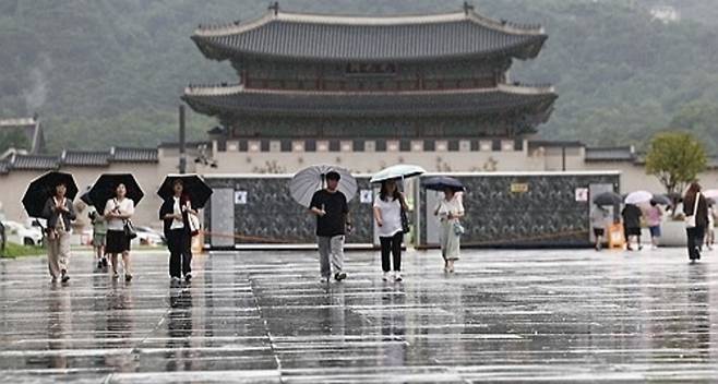 ▲ 비가 내린 지난 14일 서울 종로구 광화문광장에서 시민들이 이동하고 있다. /연합뉴스