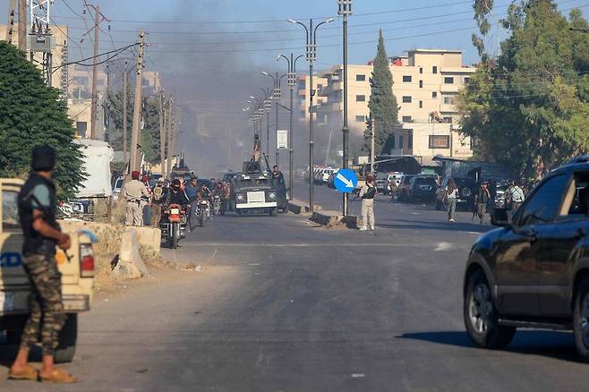 14일(현지시각) 시리아 남부 스웨이다의 드루즈족 거주지에서 베두인족과 드루즈족 사이의 충돌이 발생했다. 시리아 정부군이 연기가 나는 곳을 바라보고 있다. 스웨이다/AFP 연합뉴스