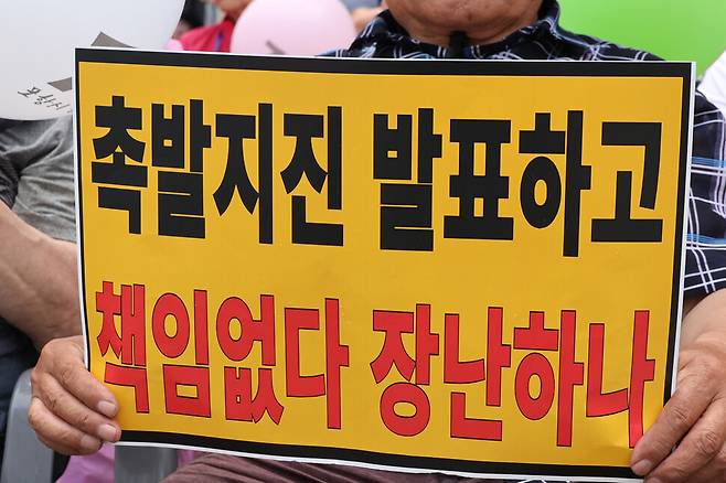 경북 포항지진 정신적 손해배상 소송의 항소심 패소 판결과 관련해 포항지진 범시민대책본부가 지난달 13일 포항 육거리 인근 중앙상가에서 개최한 시민궐기대회에서 시민들이 항의 손팻말을 들고 있다. 연합뉴스