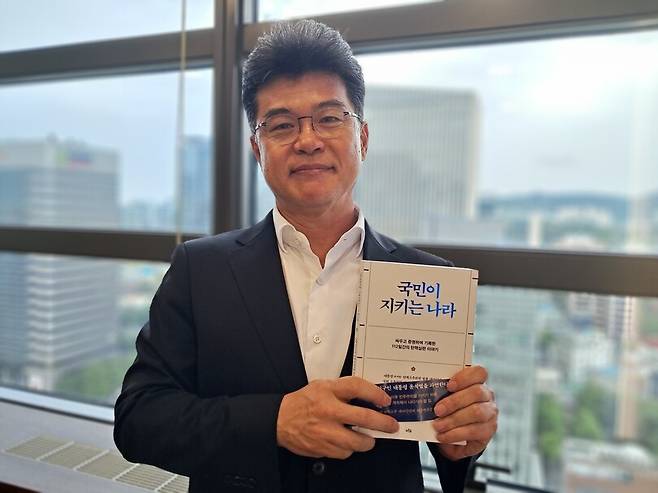 윤석열 탄핵소추 대리인단의 실무총괄을 맡았던 김진한 변호사가 14일 오후 서울 종로구 법무법인 클라스한결 회의실에서 최근 출간한 책 ‘국민이 지키는 나라’를 들고 포즈를 취하고 있다. 고경태 기자