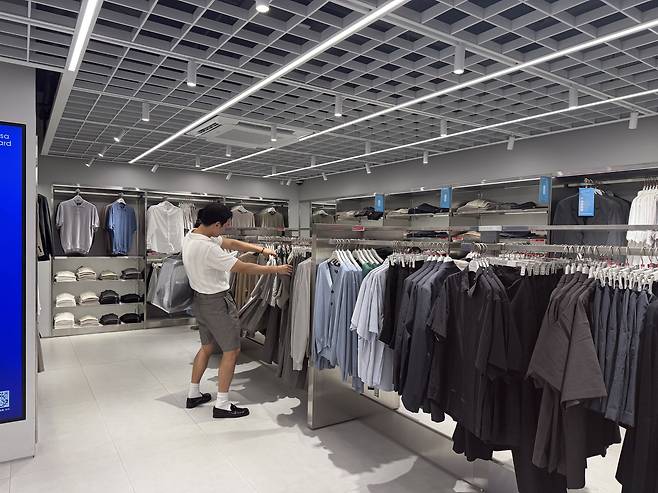 Fashion stylist Rams selects outfits for Aban during a shopping tour at Musinsa Standard in Myeong-dong, central Seoul. [WOO JI-WON]