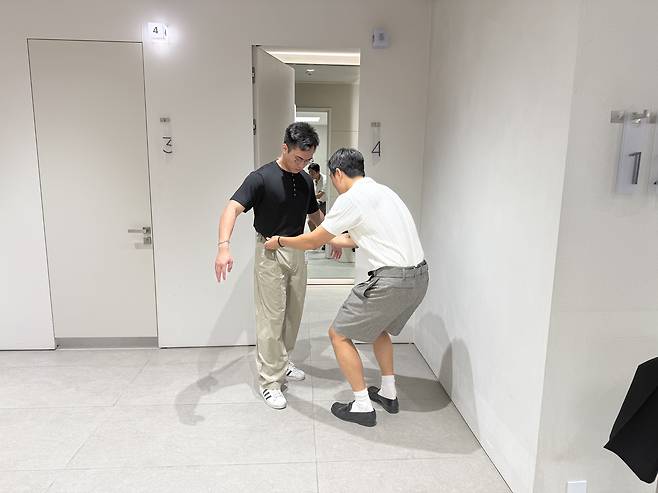 Fashion stylist Rams helps Jeremy tuck in his shirt at 8Seconds in Myeong-dong, central Seoul. [WOO JI-WON]