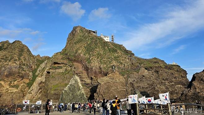 (독도=뉴스1) 최창호 기자 = 독도의 날인 25일 오후 경북 울릉군 울릉읍 독도를 찾은 관광객들이 태극기와 함께 섬 주변을 돌아보고 있다. (대저해운 제공) 2024.10.25/뉴스1  Copyright (C) 뉴스1. All rights reserved. 무단 전재 및 재배포,  AI학습 이용 금지.