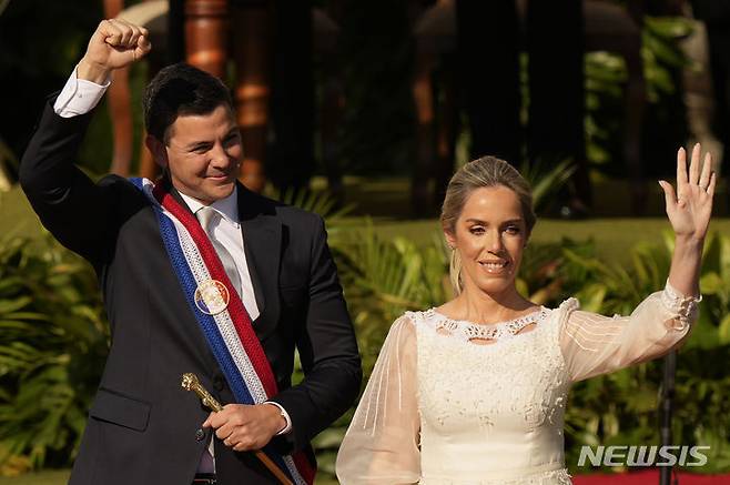 [아순시온=AP/뉴시스] 산티아고 페냐 파라과이 대통령이 2023년 8월 15일 아순시온에서 대통령 선서를 마치고 부인 레티시아 오캄포스와 함께 손을 흔들고 있다. 이날 취임식에는 루이스 이나시우 룰라 다시우바 브라질 대통령, 알베르토 페르난데스 아르헨티나 대통령, 필리페 6세 스페인 국왕, 라이칭더 대만 부총통 등이 참석했다. 한국에서는 원희룡 국토부 장관이 특사로 참석했다. 2025.07.15.