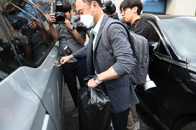 김건희 여사 관련 의혹들을 수사하는 민중기 특별검사팀이 15일 서울 역삼동 건진법사 전성배 씨의 법당에 대한 압수수색을 마친 후 관련 물품을 들고 차로 향하고 있다. 연합뉴스