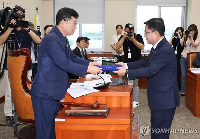 선서문 전달하는 김성환 환경부 장관 후보자 (서울=연합뉴스) 김주성 기자 = 김성환 환경부 장관 후보자 15일 국회 정무위원회에서 열린 인사청문회에 출석해 안호영 위원장에게 선서문을 전달하고 있다. 2025.7.15 utzza@yna.co.kr
