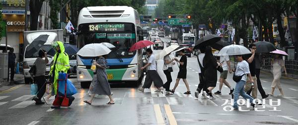 비가 내리며 흐린 날씨가 이어진 16일 오후 수원시내 한 횡단보도에서 우산을 쓴 시민들이 발걸음을 재촉하고 있다. 2025.7.16 /최은성기자 ces7198@kyeongin.com