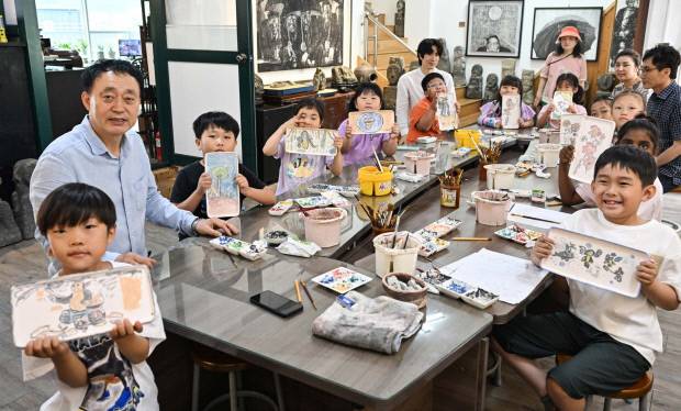 ‘마을학교 프로그램’에 참여한 초등학생들과 기념촬영을 하고 있는 박주생 관장(왼쪽). <최현배 기자>