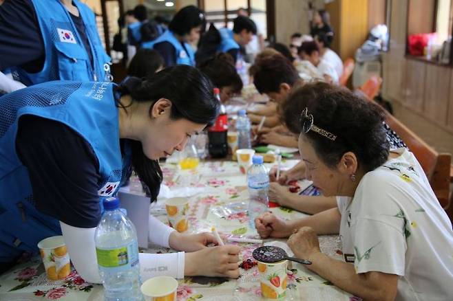 지난 7일 사마르칸트 고려인문화센터에서 봉사단원이 고려인 어르신과 함께 전통문화체험을 하고 있다. 지구촌나눔운동