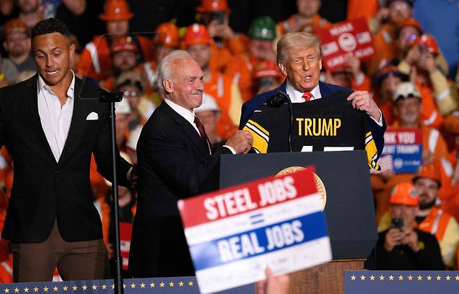 도널드 트럼프 미국 대통령이 2025년 5월 펜실베이니아주 웨스트 미플린에 있는 US 스틸-어빈 공장에서 열린 집회에서 로키 블라이어로부터 피츠버그 스틸러스 유니폼을 받고 있다. /연합뉴스