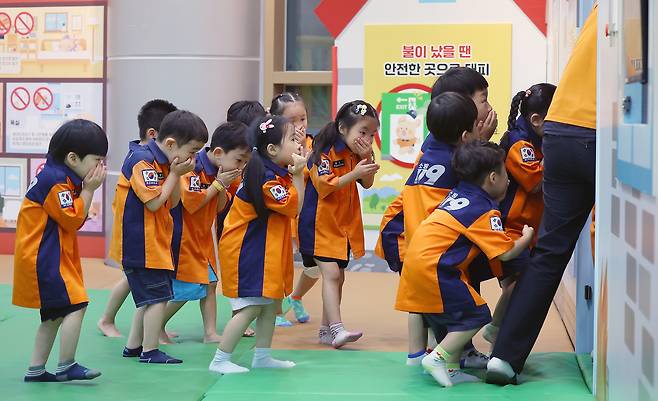 Children participate in a fire evacuation drill at the Busan 119 Safety Experience Center in Dongnae District, Busan, on July 16. The training follows a recent tragedy in Busan in which young sisters died in an apartment fire while their parents were away. In response, the Ministry of Education, local education offices and the National Fire Agency have pledged to strengthen fire safety and emergency response education for children. [YONHAP]