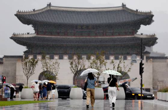 People walk in the rain under umbrellas on Gwanghwamun Square in Jongno District, central Seoul, on July 16. [YONHAP]