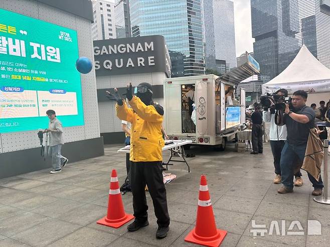 [서울=뉴시스]최은수 기자=16일 오전 서울 강남역 스퀘어광장에서 열린 '5대 반칙 운전 관련 교통안전 캠페인'에서 한 퀵 배달기사가 음주상태 체험 고글을 쓰고 공을 받는 체험에 참여하고 있다. 2025.07.16