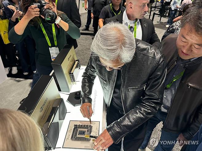 삼성전자 GDDR7에 친필 사인하는 엔비디아 젠슨 황 CEO (새너제이[미 캘리포니아주]=연합뉴스) 김태종 특파원 = 젠슨 황 엔비디아 최고경영자(CEO)가 연례 개발자 콘퍼런스 GTC 2025 넷째 날인 20일(현지시간) 삼성전자 부스를 찾아 그래픽 메모리 GDDR7에 친필 사인을 하고 있다. 2025.3.21 taejong75@yna.co.kr