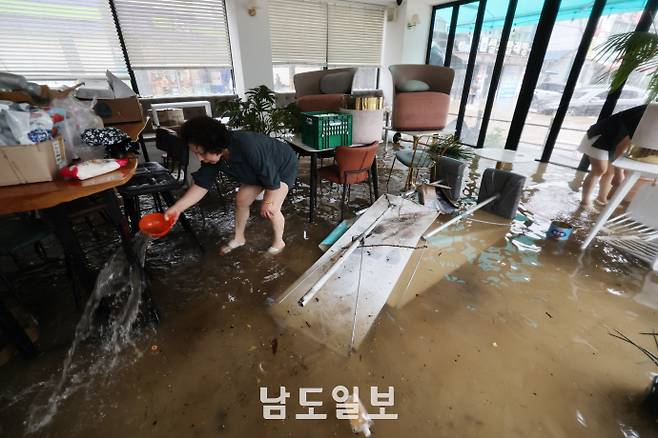 불어난 빗물, 침수된 상가호우경보가 발효된 17일 광주광역시 북구 용봉동 인근 상가가 물에 잠겨 상인이 배수 작업을 하고 있다. /임문철 기자 35mm@namdonews.com