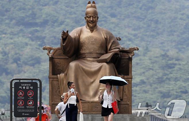 서울 종로구 광화문광장에서 외국인 관광객들이 휴대용 선풍기로 더위를 식히며 걷고 있다. 2024.8.13/뉴스1 ⓒ News1 오대일 기자