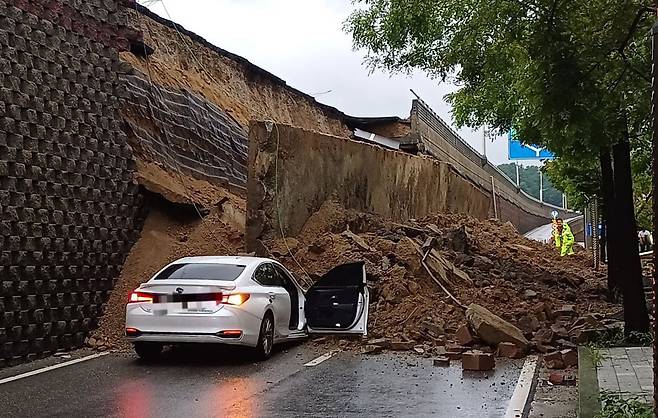 수도권 등 중부지역에 호우주의보가 발효된 16일 경기 오산시 가장교차로 옹벽이 도로로 무너져 차량을 덮치는 사고가 발생해 소방 당국이 대응 1단계를 발령, 구조작업을 벌이고 있다. /경기도소방재난본부