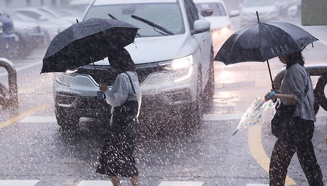 폭우가 쏟아진 17일 오전 서울 서초구 서울중앙지법 인근에서 우산 쓴 시민들이 출근을 하고 있다. /뉴스1