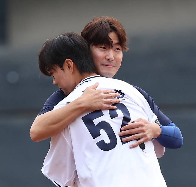 6일 은퇴 경기를 치른 김재호(왼쪽)가 박준순에게 자신의 유니폼을 입혀 준 뒤 포옹하는 모습. 김재호는 “수비를 잘해야 한다. 송구를 신경 쓰면 된다. 타격은 나보다 낫다”고 박준순을 격려했다. 두산 제공