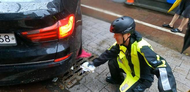 17일 오후 1시 반경 광주 북부소방서 박선홍 소방위 등 구조대원들이 중흥동 전남대 정문 주택가 배수작업을 하다 현금 봉투를 발견하는 모습. 광주 북부소방서 제공.