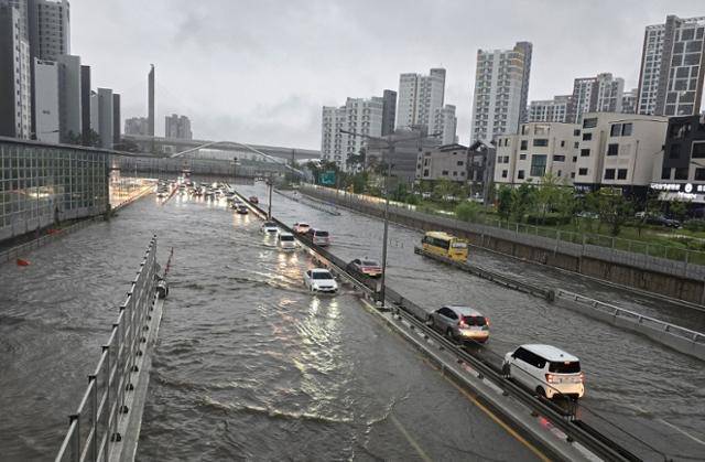 17일 오전 8시 경 충남 아산시 배방읍 국도21호선 이순신고등학교 인근 지하차도 입구 도로가 폭우로 침수됐지만 차량 통제가 이뤄지지 않아 차량들이 물속을 뚫고 위험하게 주행하고 있다. 독자 제공