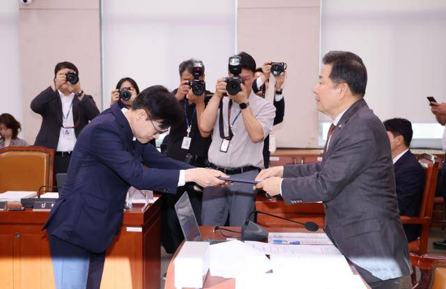 김정관 산업통상자원부 장관 후보자가 17일 오전 서울 여의도 국회 산업통상자원중소벤처기업위원회에서 열린 인사청문회에서 이철규 위원장에게 선서문을 전달하고 있다. 뉴시스