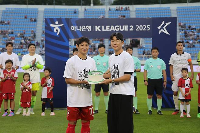 이승기(오른쪽)가 지난 12일 부산구덕운동장에서 열린 성남FC와의 하나은행 K리그2 2025 20라운드를 앞두고 부산 주장 장호익으로부터 기념 케이크를 전달받고 있다. 사진=부산