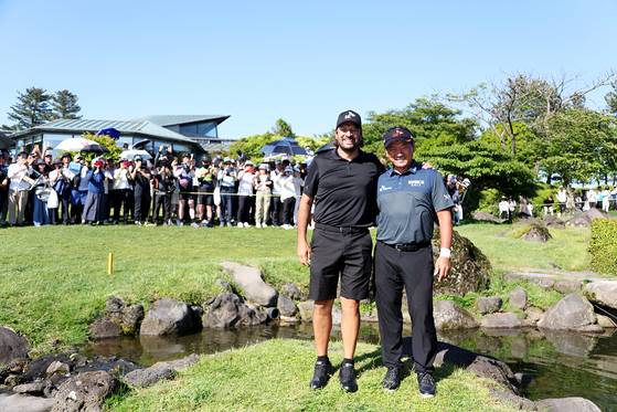 지난해 SK텔레콤 오픈 연장전 우승을 안긴 18번홀 앞 작은 섬에서 캐디(왼쪽)와 기념 촬영한 최경주. [뉴시스]