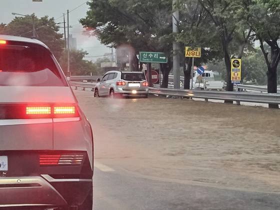 17일 오전 충남 서산시 해미면 해미톨게이트 앞 도로가 호우로 침수돼 차량이 서행하고 있다. 연합뉴스