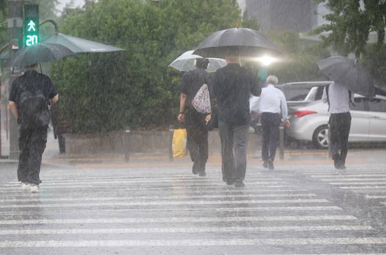 서울 서남권에 호우주의보가 발효된 8일 서울 영등포구 여의도 국회 인근에서 시민들이 우산을 쓰고횡단보도를 건너고 있다. 연합뉴스