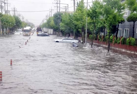 광주·전남 지역에 시간당 최고 86㎜의 호우가 내린 17일 오후 광주 광산구 한 도로가 침수돼 차량이 빗물에 잠겨 있다. 사진 독자, 연합뉴스