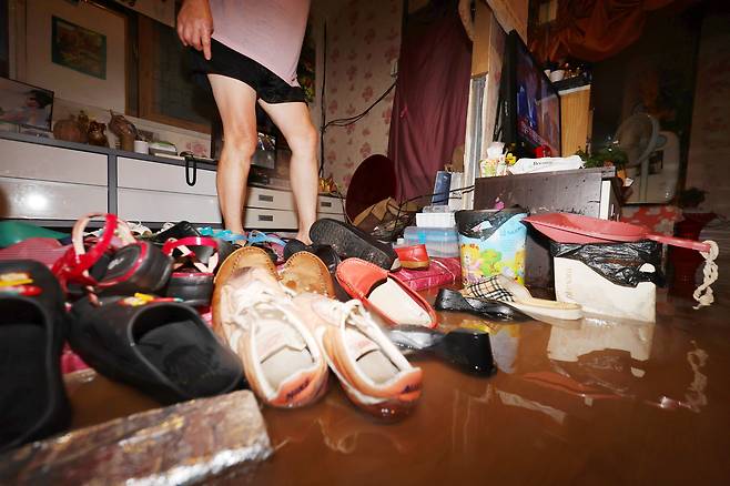 호우경보가 발효된 17일 오전 광주 남구 백운광장 인근 상가가 물에 잠겨 상인이 배수 작업을 하고 있다. 연합뉴스