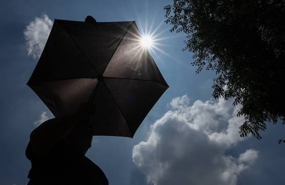 A local holds a sun umbrella in Seongdong District, eastern Seoul, on July 9, 2025. [NEWS1]