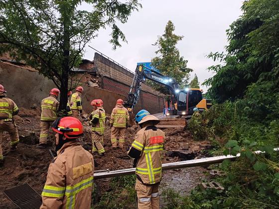 Firefighters respond after a retaining wall under an overpass collapses and crushes a vehicle passing beneath at Gajang Interchange in Osan, Gyeonggi, on July 16. [GYEONGGI FIRE AND DISASTER HEADQUARTERS]