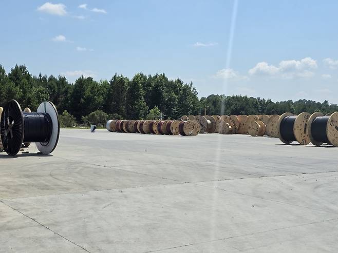 LS CUS 타보로 공장 밖 적치장에 전력케이블 드럼이 줄지어 쌓여 있다. LS CUS