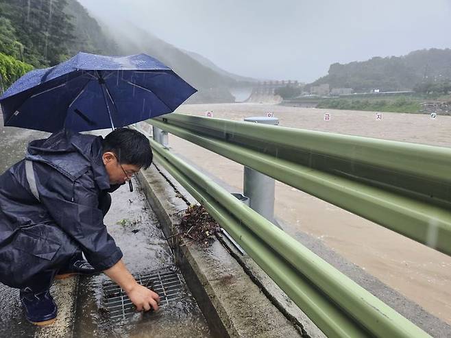 [괴산=뉴시스] 안성수 기자 = 17일 괴산댐 인근 도로에서 군 직원이 배수로를 정리하고 있다. 2025.7.17. hugahn@newsis.com