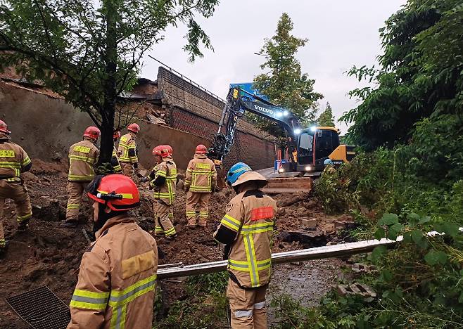 16일 오후 경기 오산시 가장교차로 고가도로의 10ｍ 높이 옹벽이 도로로 무너지며 차량 2대를 덮치는 사고가 발생해 소방대원들이 구조작업을 하고 있다. 경기도소방재난본부 제공